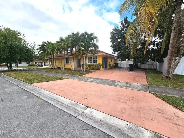 a front view of a house with a yard and trees