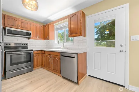 a kitchen with granite countertop white cabinets and appliances