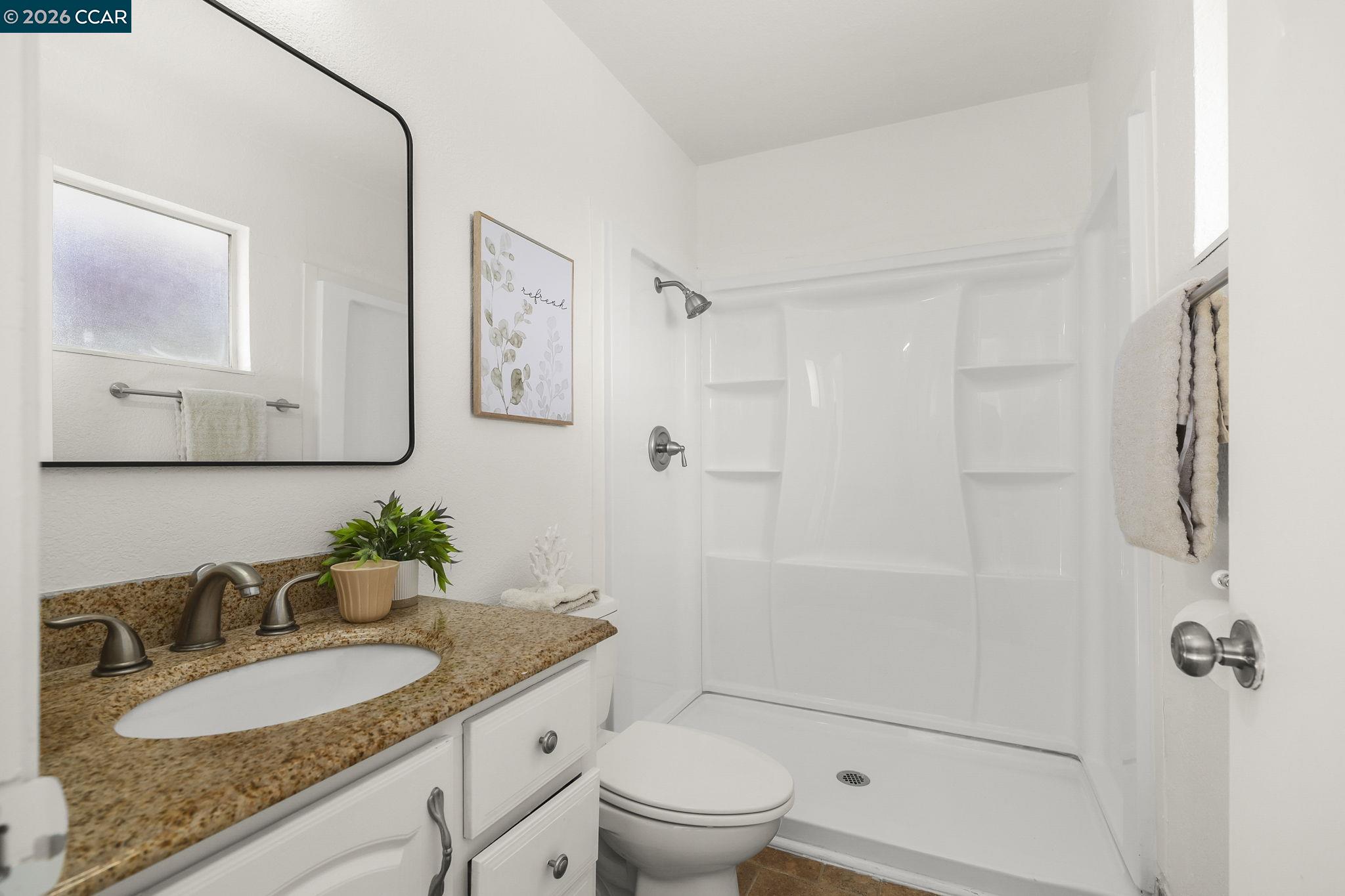 476 Pamela Drive Bay Point, CA 94565 - Photo 5 of 24 a bathroom with a granite countertop sink a toilet and shower
