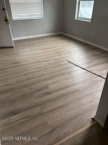 a view of a room with wooden floor and window