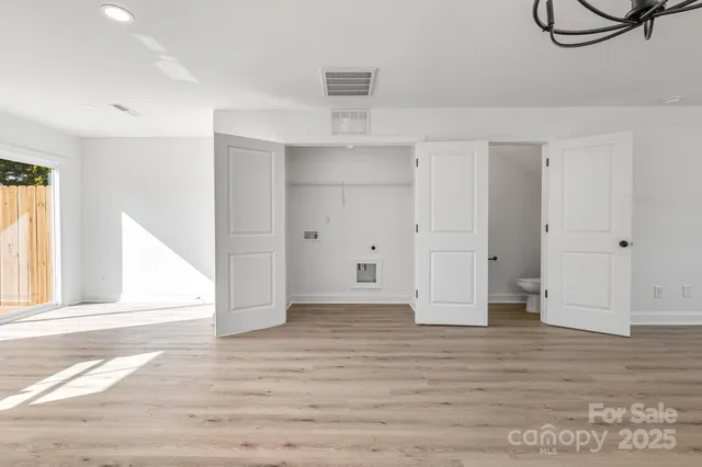 a view of empty room with wooden floor and window