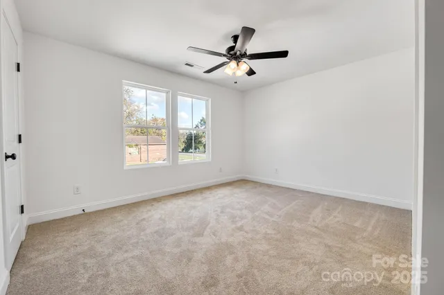 a view of a big room with windows and chandelier fan