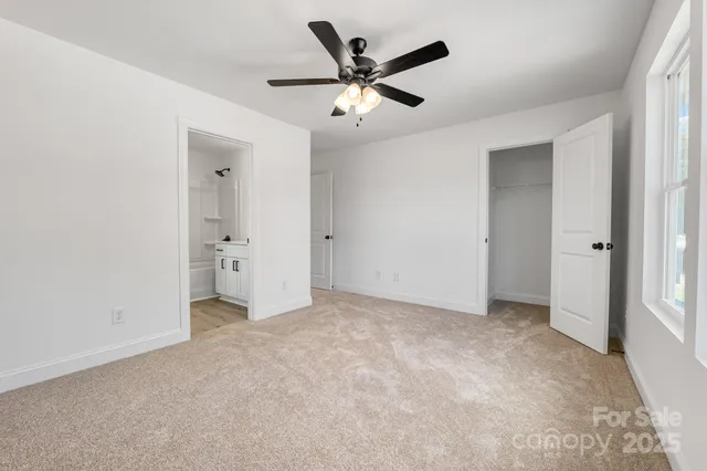 an empty room with closet and a ceiling fan