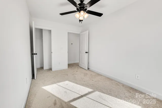 a view of a livingroom with a ceiling fan and window