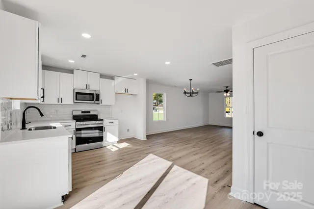 a kitchen with stainless steel appliances granite countertop a refrigerator and a sink
