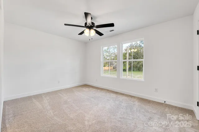 an empty room with closet and ceiling fan