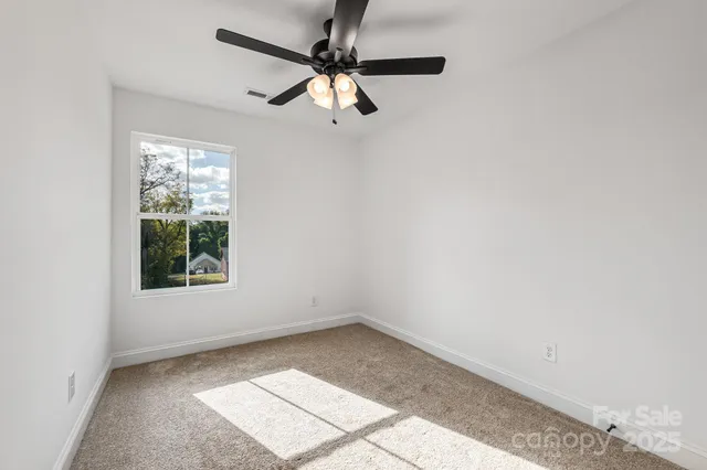 an empty room with chandelier fan