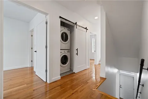 a view of a storage and utility room with wooden floor