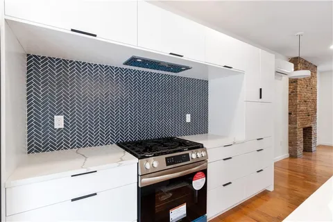 a kitchen with a stove cabinets and wooden floor