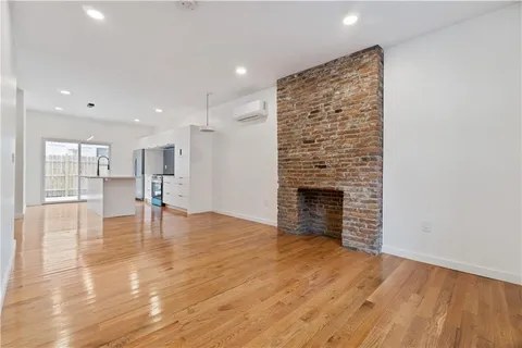a view of empty room with wooden floor and fireplace