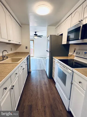 a kitchen with granite countertop white cabinets and white appliances