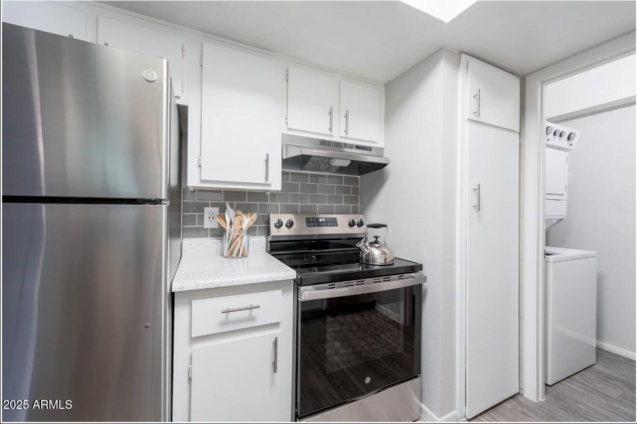 2311 East Union Hills Drive, Unit 1 Phoenix, AZ 85024 - Photo 3 of 11 a kitchen with a refrigerator stove and white cabinets