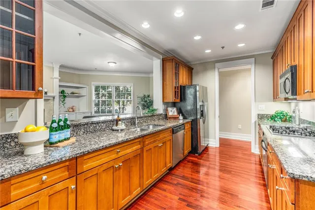 a large kitchen with granite countertop a large counter top stainless steel appliances and windows