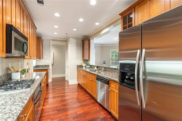 a large kitchen with stainless steel appliances granite countertop a stove and a refrigerator