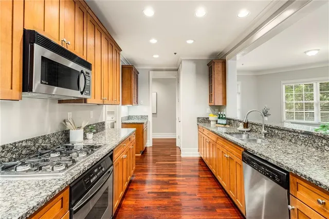 a large kitchen with stainless steel appliances granite countertop a lot of counter space and a sink