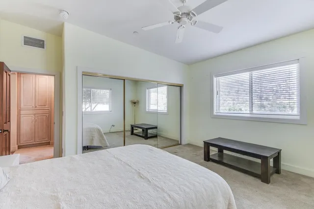 a spacious bedroom with a bed and a dresser in it