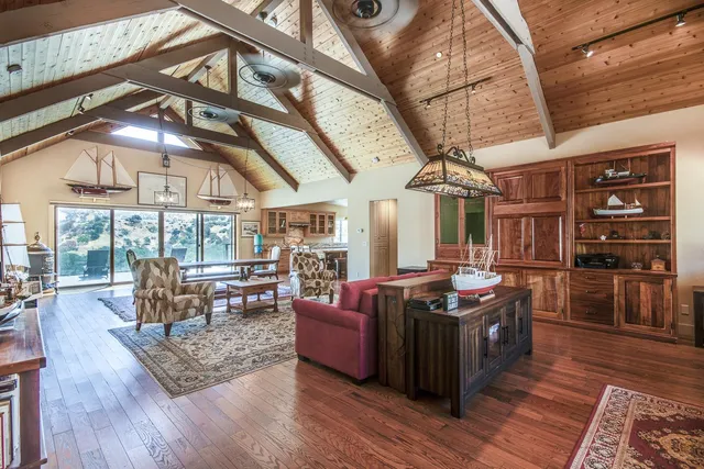 a living room with furniture a flat screen tv and wooden floor