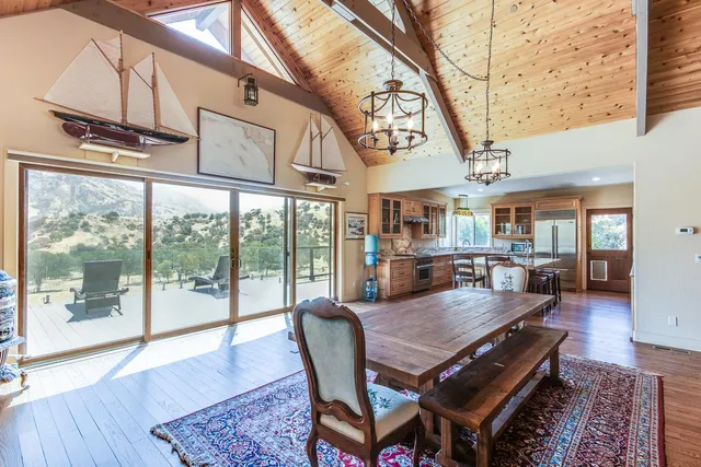 a dining area with furniture a rug and wooden floor
