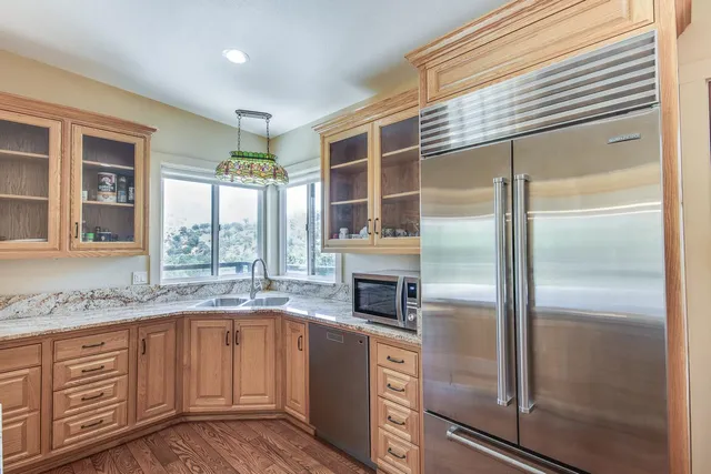 a kitchen with granite countertop a refrigerator and a sink
