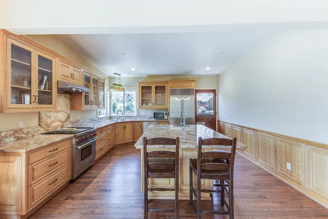 a kitchen with stainless steel appliances granite countertop a stove and wooden floor