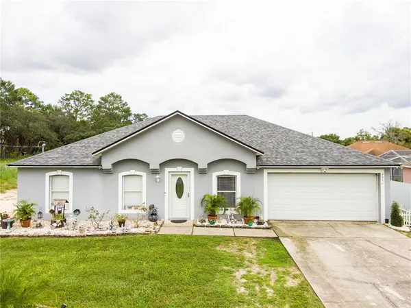 a front view of a house with a garden and yard