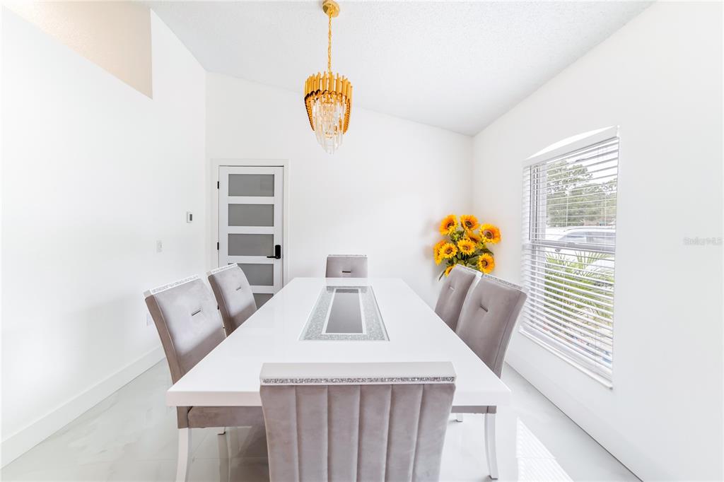 Undisclosed Address Spring Hill, FL 34609 - Photo 11 of 32 a view of a dining room with furniture and wooden floor