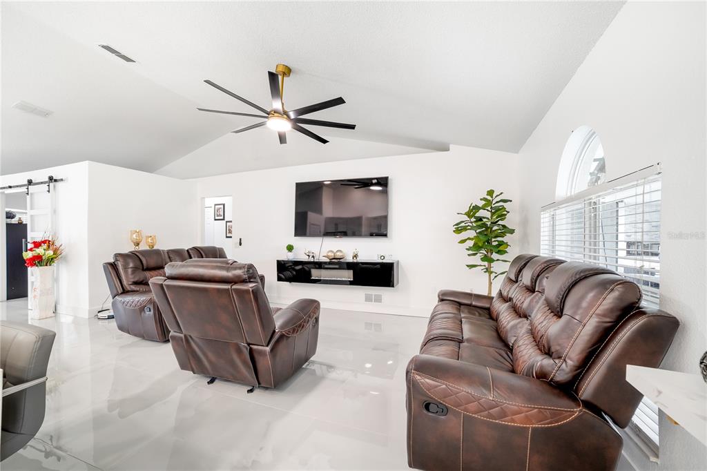 Undisclosed Address Spring Hill, FL 34609 - Photo 15 of 32 a living room with furniture and a flat screen tv