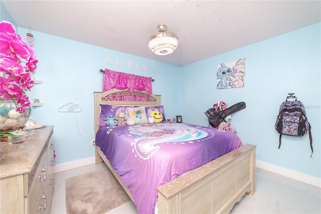 Undisclosed Address Spring Hill, FL 34609 - Photo 18 of 32 a bedroom with a bed and a chandelier