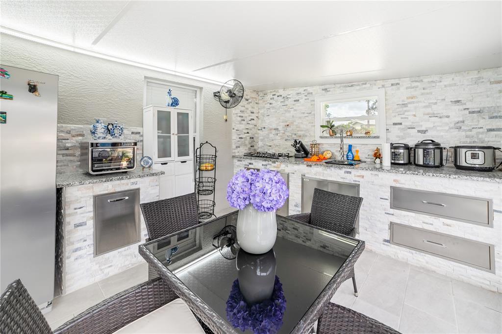 Undisclosed Address Spring Hill, FL 34609 - Photo 22 of 32 a kitchen with stainless steel appliances kitchen island granite countertop a sink and cabinets