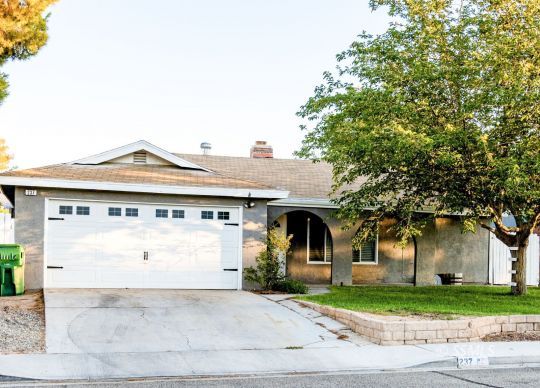 237 West Rader Avenue Ridgecrest, CA 93555 - Photo 1 of 37 a view of a white house with a large tree and a yard