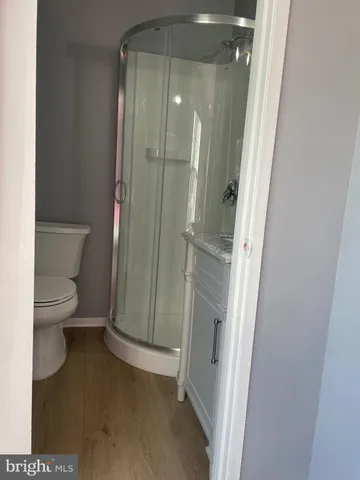 a bathroom with a granite countertop shower and a toilet