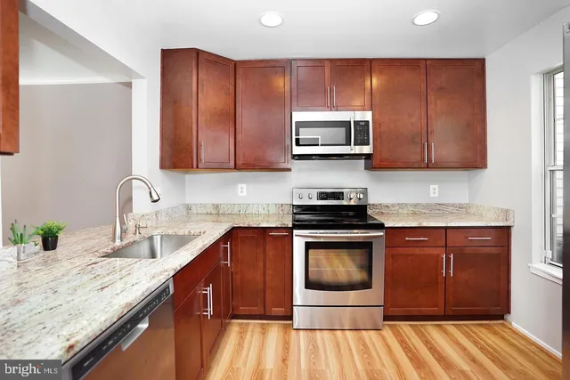 a kitchen with stainless steel appliances granite countertop a sink stove and microwave