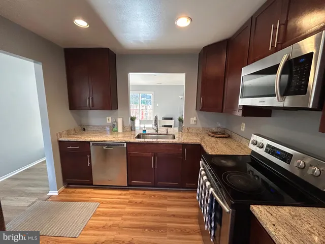 a kitchen with stainless steel appliances granite countertop a stove a sink and a microwave