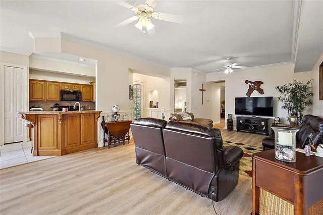 a living room with furniture a flat screen tv and kitchen view