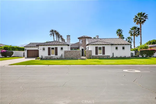 a view of a house with a big yard and potted plants