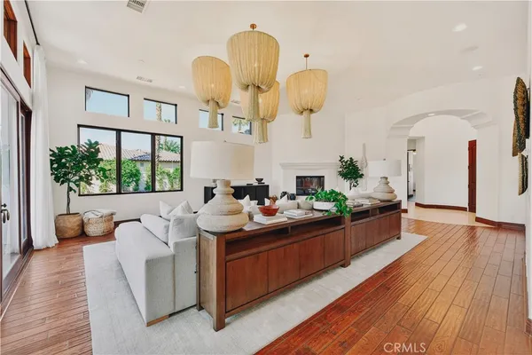 a living room with furniture kitchen view and a large window