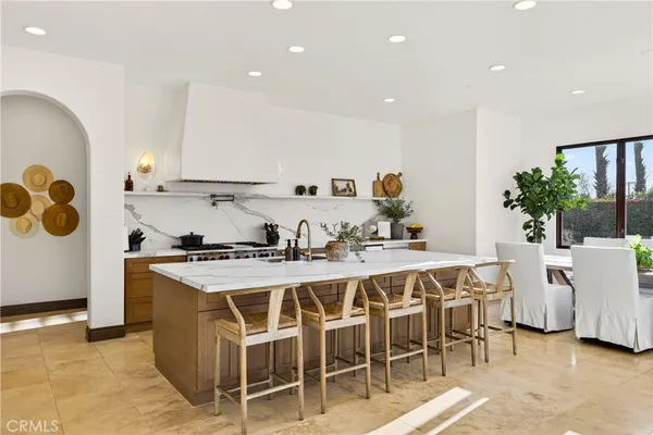 a kitchen with a dining table chairs sink and stove