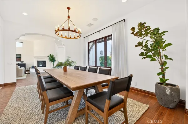 a dining room with furniture potted plants and wooden floor