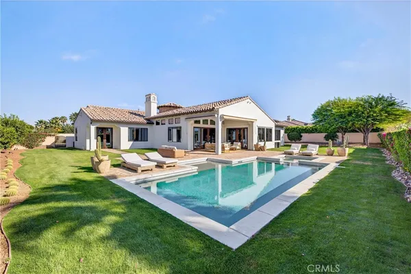 a view of a house with a yard patio and swimming pool