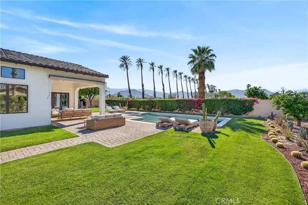 a swimming pool with outdoor seating and yard