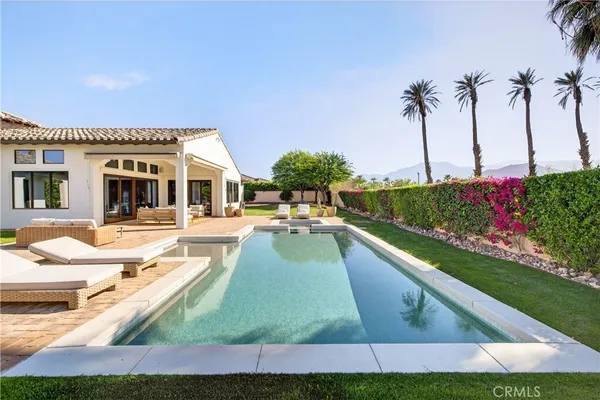 a view of a house with swimming pool and sitting area