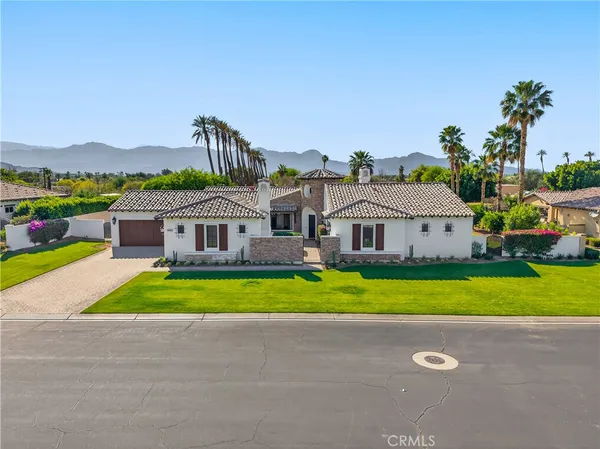 a front view of house with a garden and swimming pool