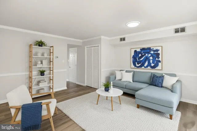 a living room with furniture a rug and a wall painting