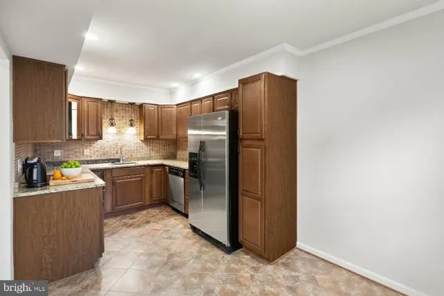 a kitchen with stainless steel appliances granite countertop a refrigerator a stove a sink and dishwasher