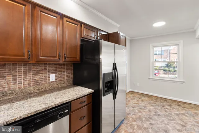 a kitchen with granite countertop a refrigerator stove top oven and sink