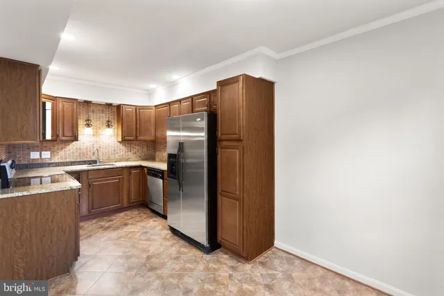 a kitchen with stainless steel appliances granite countertop a sink a stove and cabinets