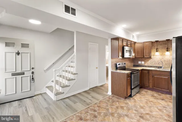 a kitchen with stainless steel appliances granite countertop a sink stove and cabinets