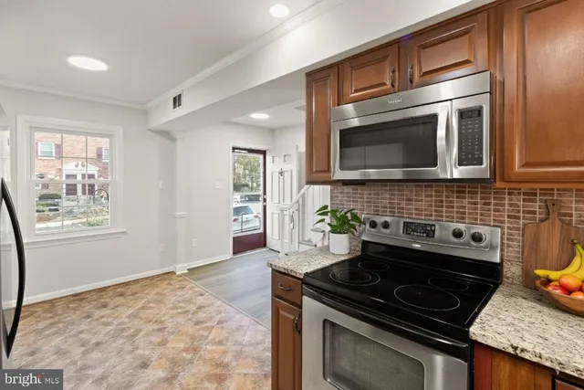 a kitchen with granite countertop cabinets stove and microwave