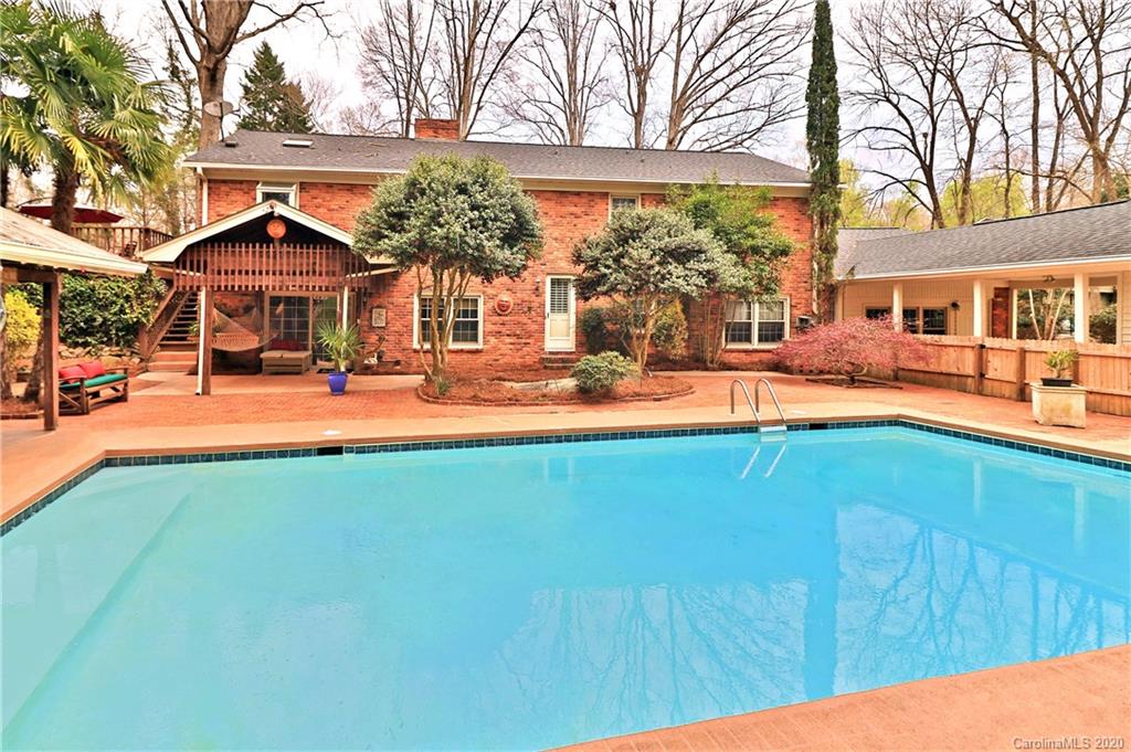 a view of a house with pool and chairs