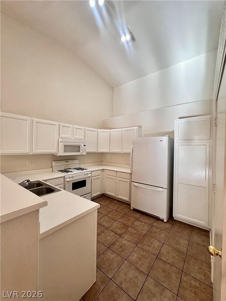 2053 Turquoise Ridge Street, Unit 202 Las Vegas, NV 89117 - Photo 4 of 18 Soaring vaulted ceilings and durable tile flooring highlight this functional kitchen space.